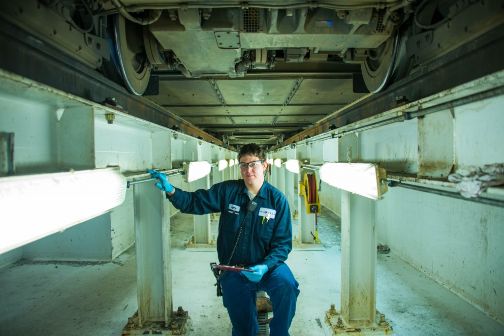 Electromechanic Tyler Hardy works on the undercarriage of a TRAX car.